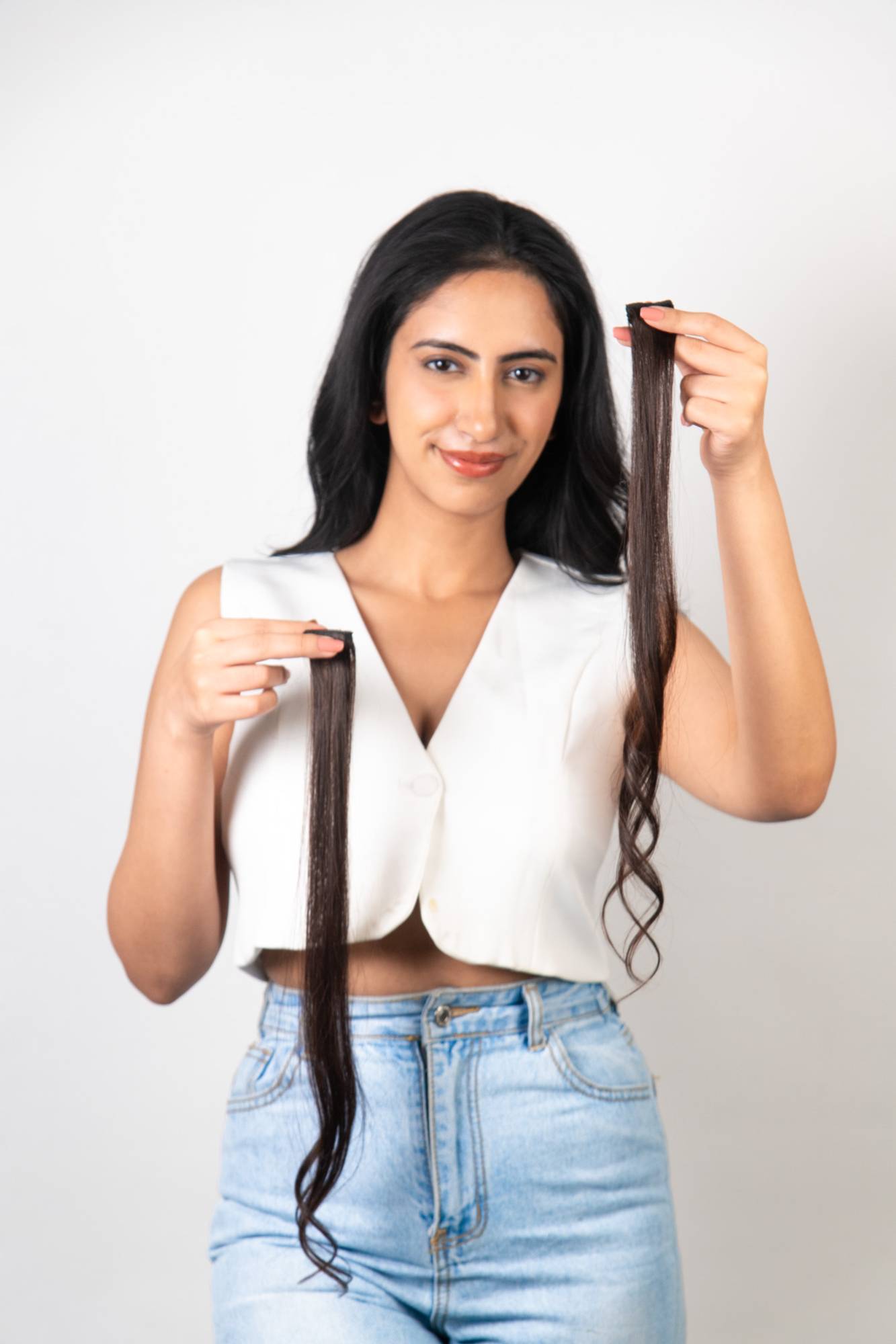 Model Holding Dolcy Dark Brown Clip-In Hair Streaks at Mid Level – Front Facing Shot Displaying Two Full Length Streaks and Showing Deep Dark Brown Shade with Natural Hair Texture