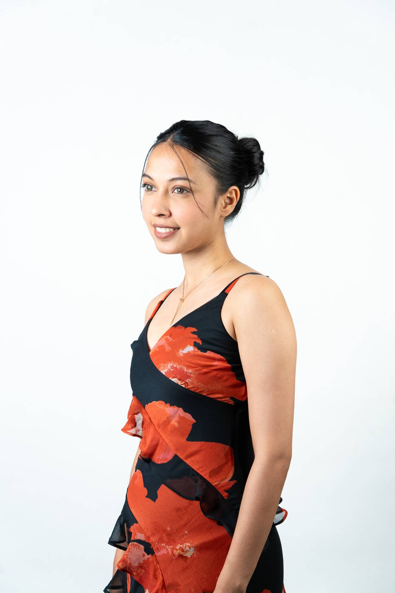 Before Look – Model's Natural Jet Black Hair in a Plain Bun Updo, Side Profile View Showing Short Natural Length Prior to Dolcy Wavy Ponytail Hair Extension Application
