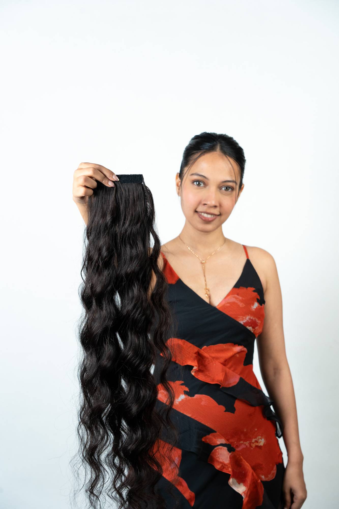 Alternate View of Dolcy Wavy Ponytail Hair Extension in Jet Black – Model Holding Product Showing Natural Wave Volume, Full Length, and Hair Quality Up Close