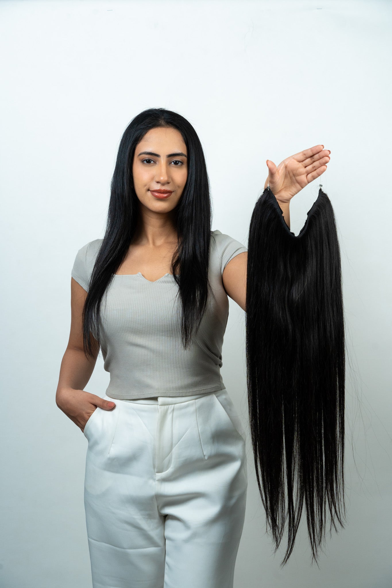 Model Holding Dolcy Halo Straight Hair Extension in Jet Black – Displaying Single Weft Patch with 5 Clips and Adjustable Invisible Wire Included in Set